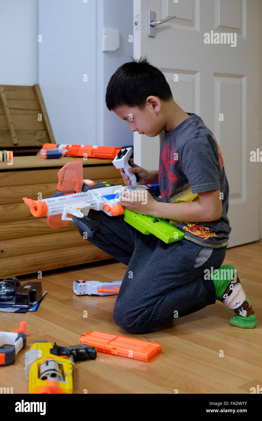 kleiner Junge spielt mit großen Spielzeugpistole in England uk Stockfoto