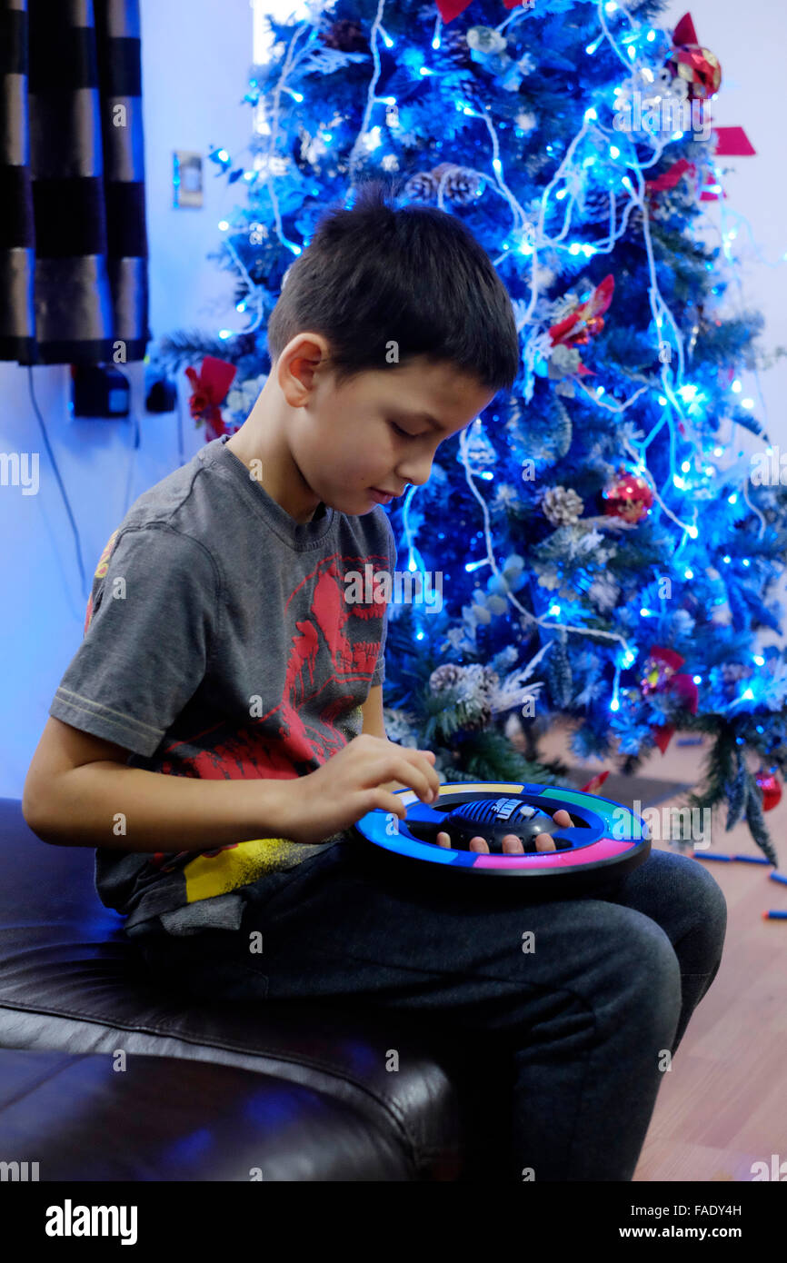 kleiner Junge spielt elektronische Spiel Weihnachtsbaum in England uk Stockfoto