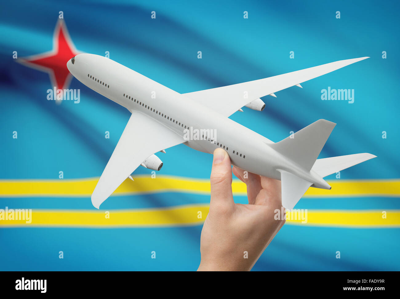 Flugzeug in der Hand mit Nationalflagge auf Hintergrund - Aruba Stockfoto