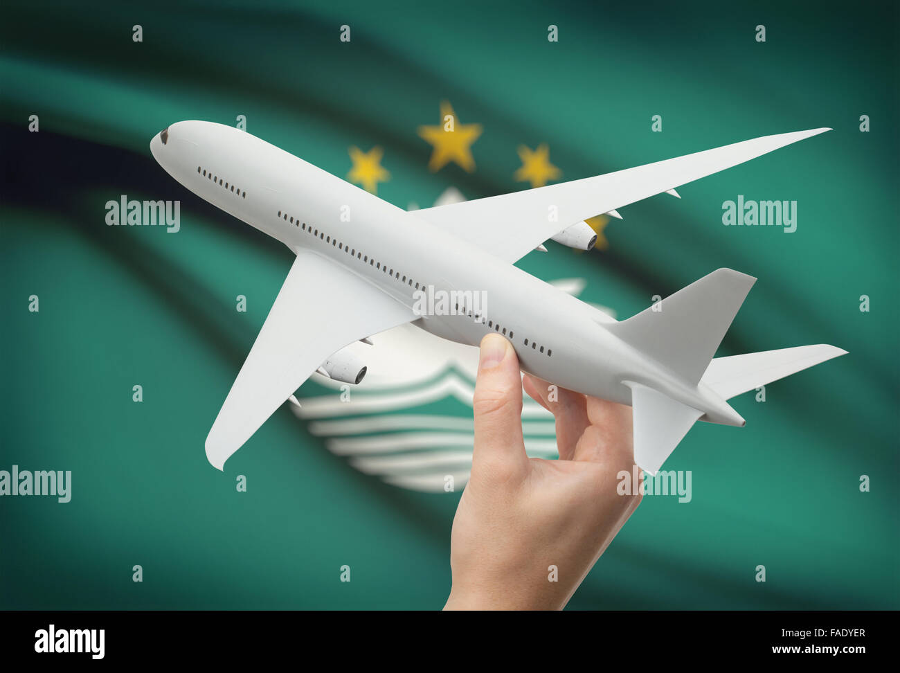 Flugzeug in der Hand mit Nationalflagge auf Hintergrund - Macau Stockfoto