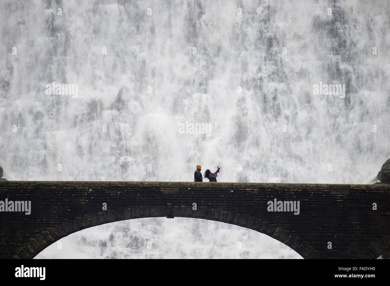 Elan-Tal, in der Nähe von Rhayader Powys Wales UK. 28. Dezember 2015.    Menschen auf der Fußgängerbrücke erhalten eine Nahaufnahme Blick nach Wochen des starken Regens das Wasser die Caban Coch-Talsperre in der Elan-Tal westlich von Rhayader Powys, Wales überragen.   Caban Coch ist die niedrigste Glied in einer Kette von 6 Talsperren und Stauseen gebaut vor hundert Jahren Einspeisung in eine 73 Meile Schwerkraft angetrieben Aquädukt, sauberes Wasser, die Stadt von Birmingham Credit zu liefern: Keith Morris/Alamy Live-Nachrichten Stockfoto