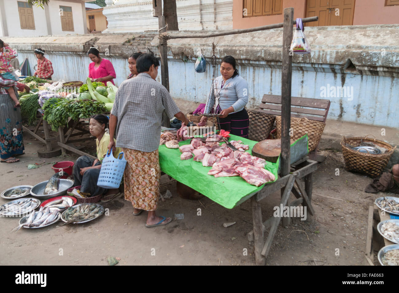 Fleisch wird gewichtet und in den frühen Morgenstunden auf einem Straßenmarkt verkauft. Shwe Kyet noch, Mandalay Region, Myanmar. Stockfoto