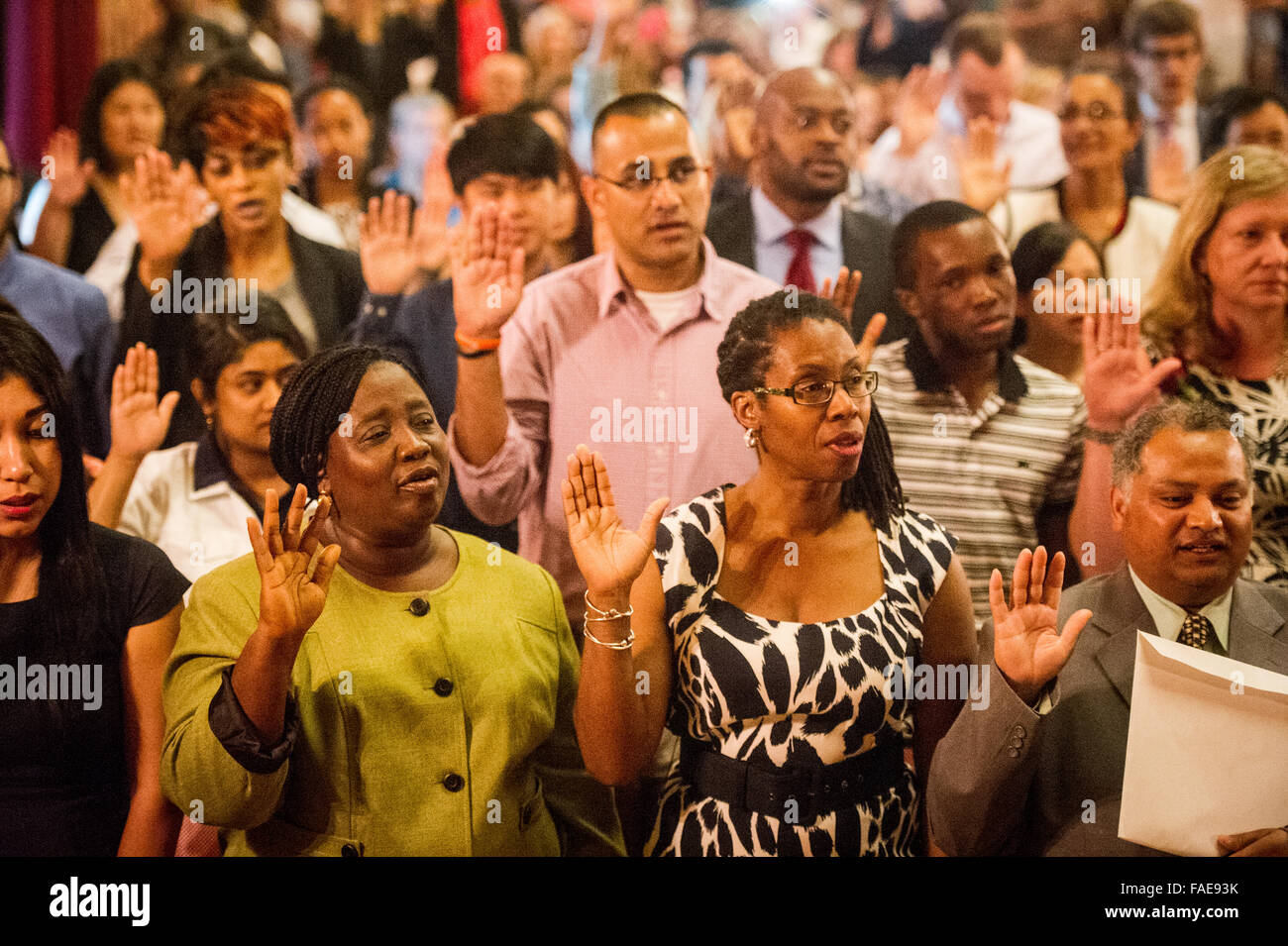 Menschen ihre Hand heben, einen Eid während einer Einbürgerung Zeremonie zu US-Bürgern zu geben. Stockfoto