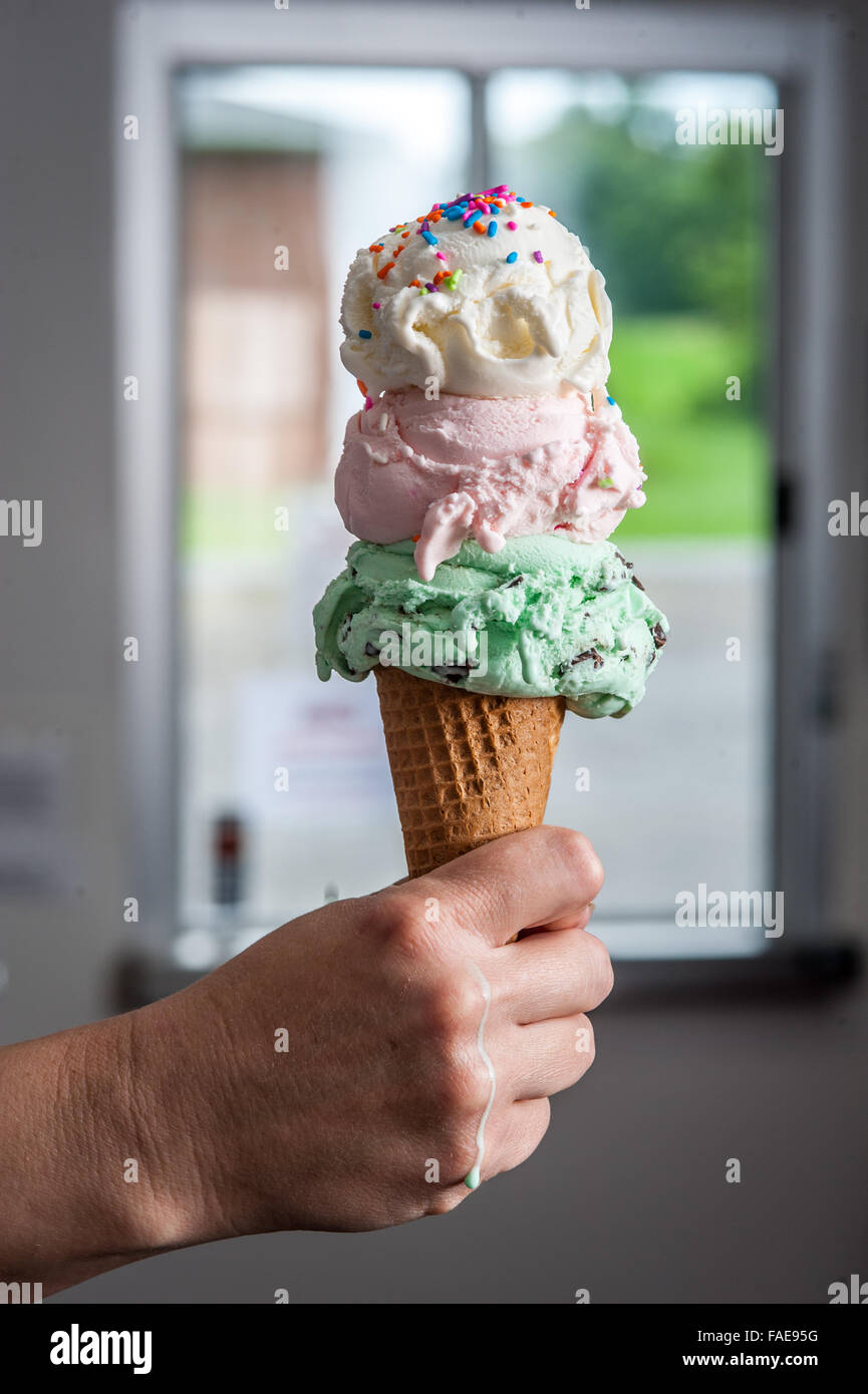 Hand, die eine drei scooped Eiswaffel Stockfoto