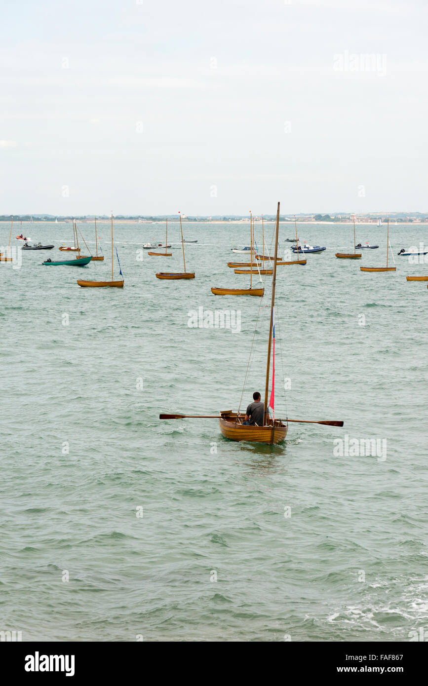Ein Mann, eine kleine Jolle im Meer vor Seaview Isle Of Wight UK an einem bewölkten Tag Rudern Stockfoto