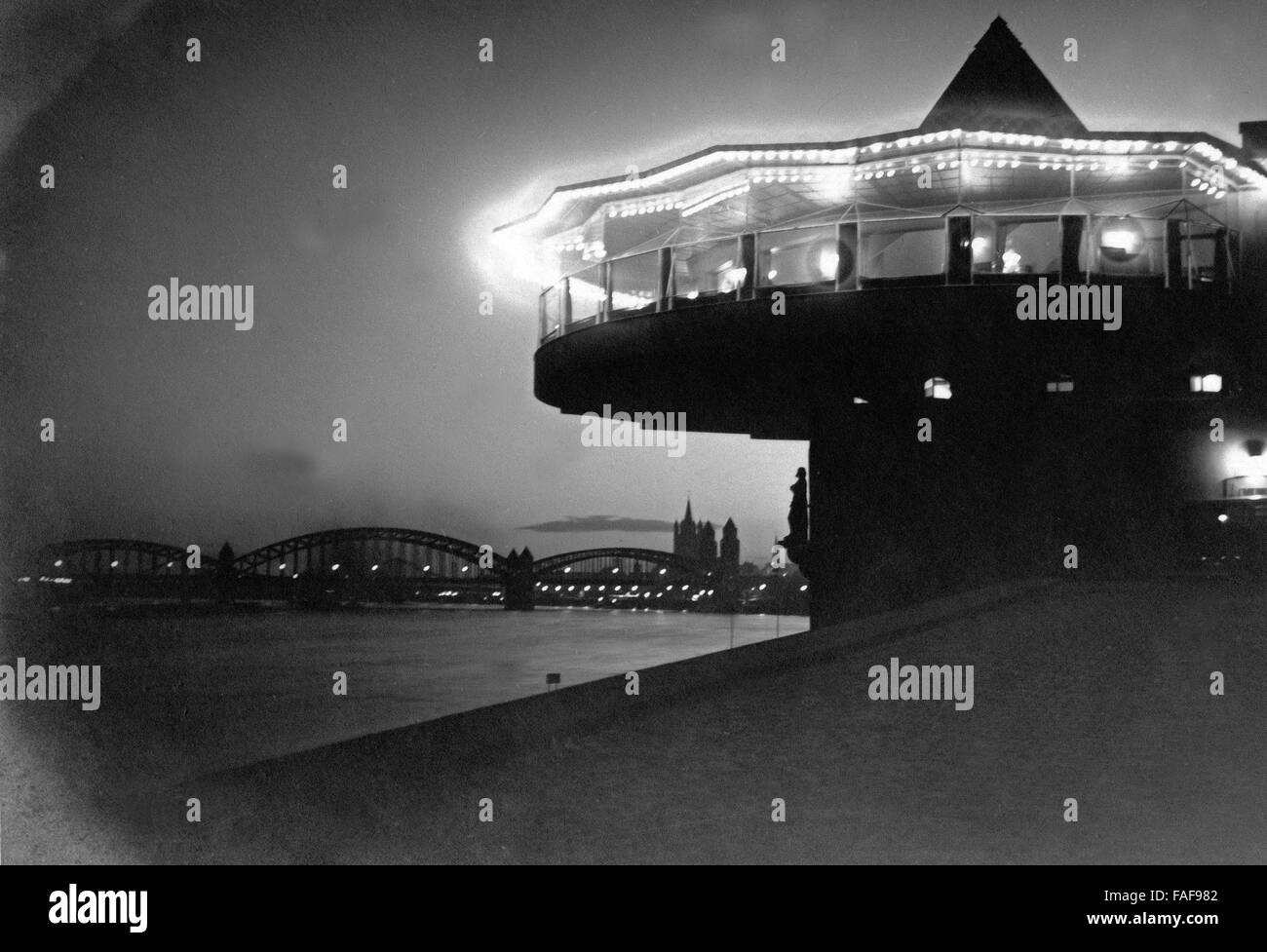 Blick Auf sterben Bastel, sterben Hohenzollernbrücke Und Die Altstadt Mit der Kirche Groß St. Martin bin Rheinufer Bei Nacht in Köln, Deutschland 1920er Jahre. Blick auf Restaurant Bastei, Hohenzollernbruecke Brücke, alte Stadt mit grober St.-Martins Kirche mit Rhein in Köln der 1920er Jahre. Stockfoto