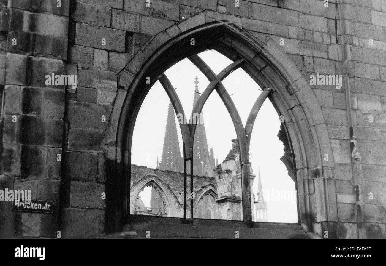 Der Dom gesehen...gabs Durch Ein Fenster in Den Ruinen der Kirche St. Kolumba in Köln, Deutschland 1940er Jahre. Die Kathedrale durch ein Fenster in die Überreste der Kirche St. Kolumba im Stadtzentrum von Köln 1940er Jahren gesehen. Stockfoto