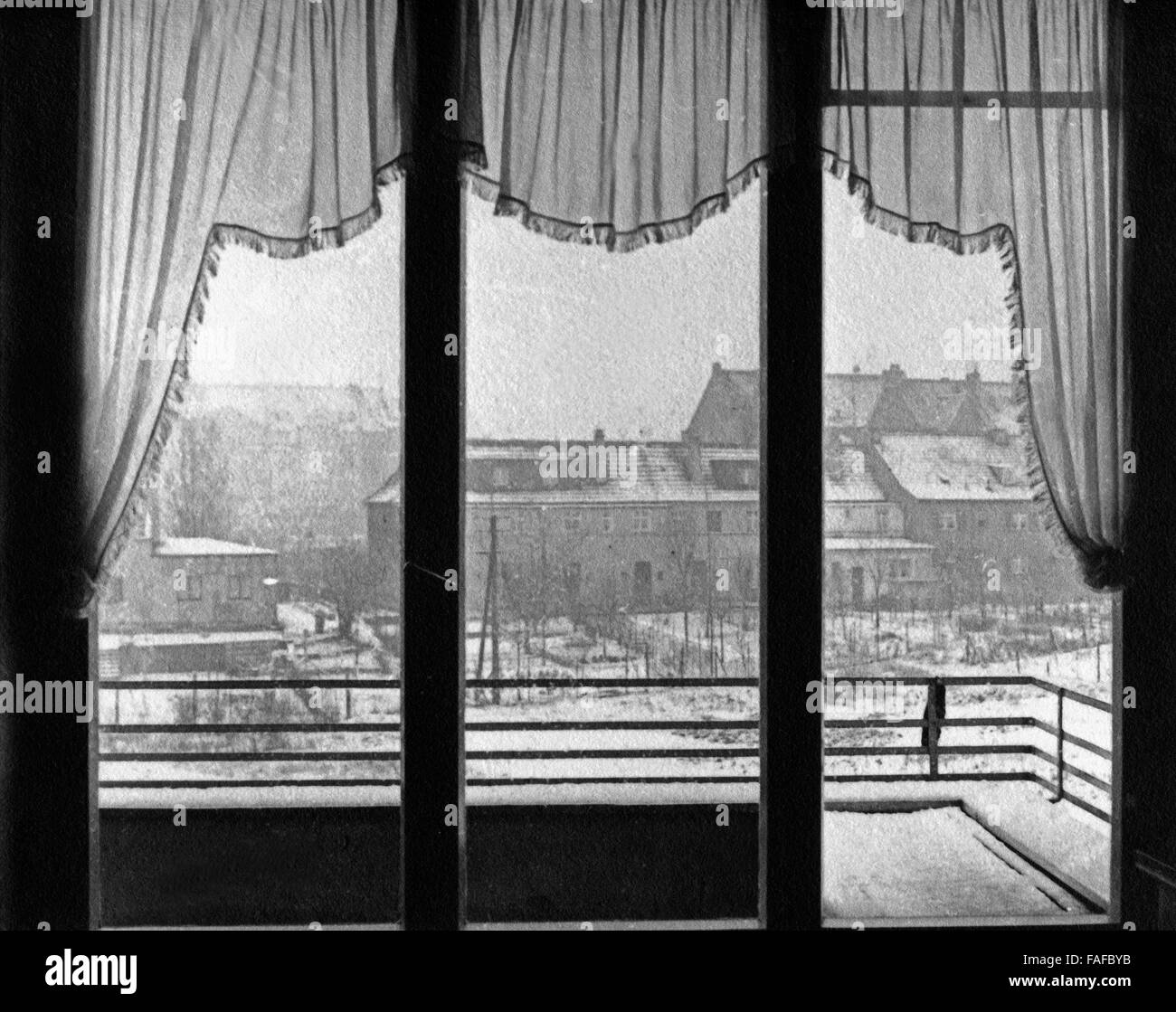 Blick aus Dem Fenster Zur Winterzeit, 1930er Jahre Deutschland. Blick durch ein Fenster im Winter, Deutschland der 1930er Jahre. Stockfoto