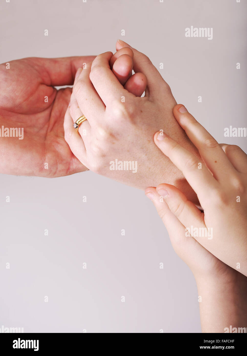 Kind hält die Hände von Mutter und Vater während einer fragmentierten und angespannte Beziehung Stockfoto