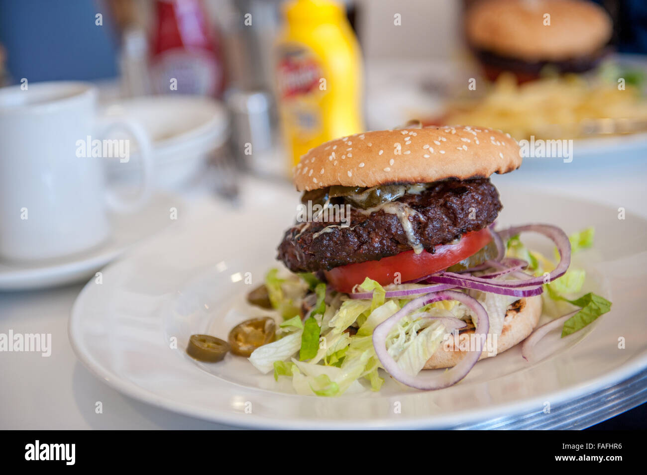 Großes amerikanisches Rindfleischburger in Brötchen essen Stockfoto