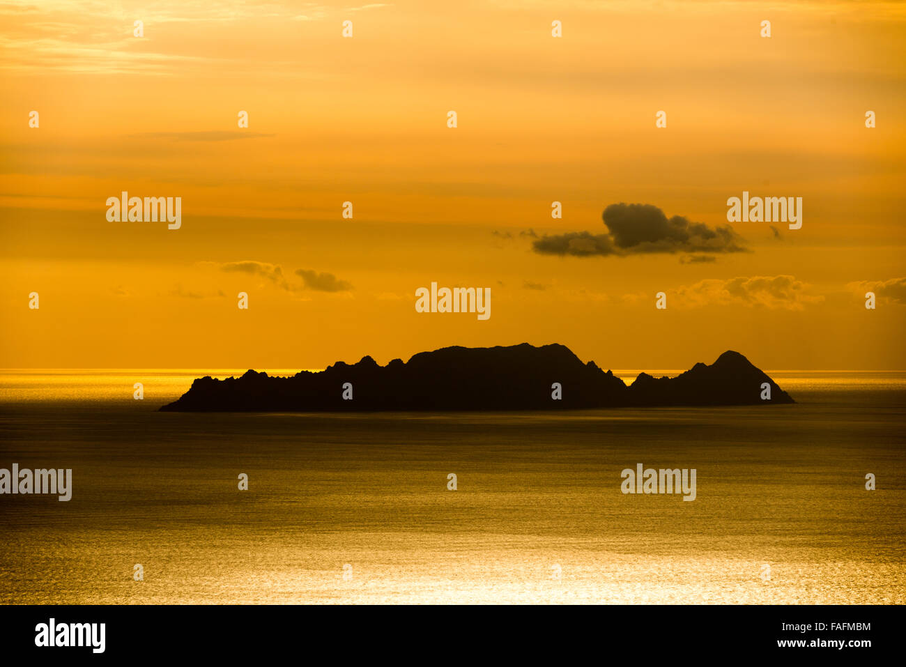 Sonnenuntergang mit rotem Himmel und Silhouette der Insel Stockfoto