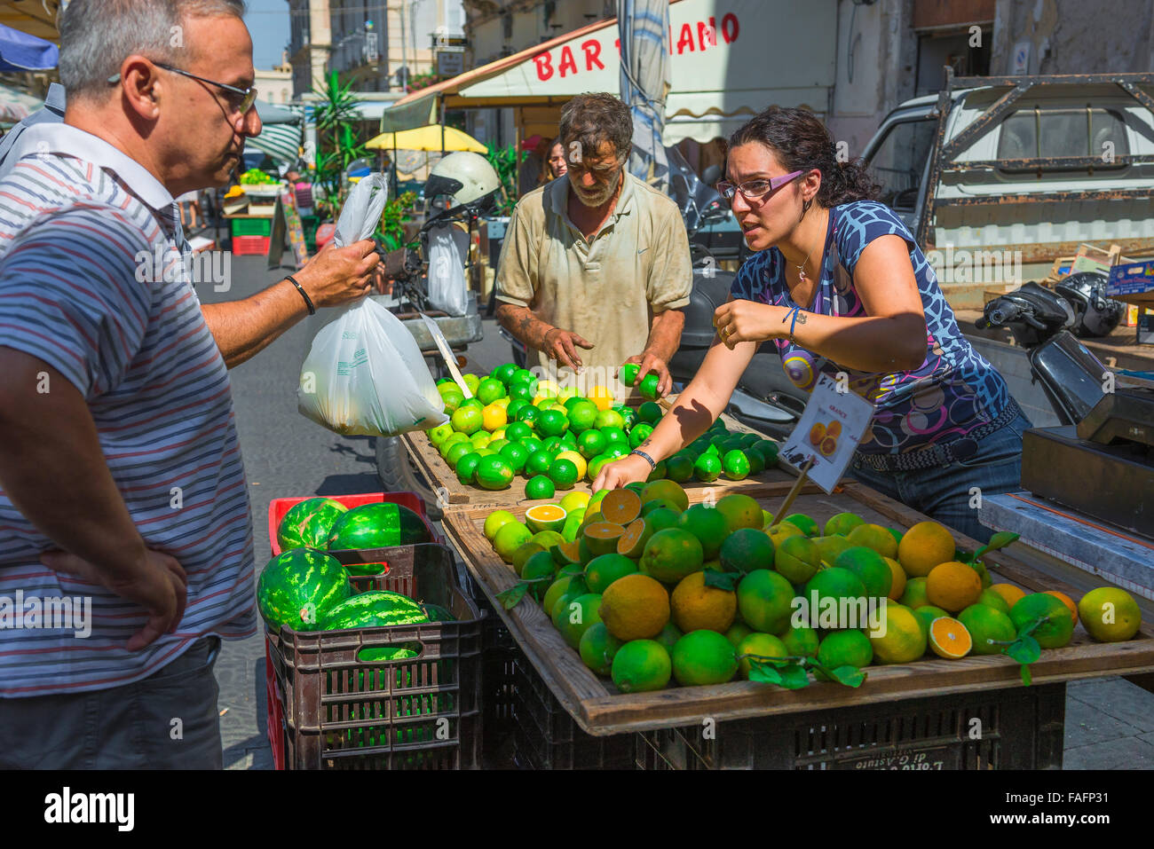 Sizilien Markt essen, Shopper kaufen frische Zitronen und Orangen aus einem Stall auf dem Markt in Ortigia, Syrakus, Sizilien, Stockfoto