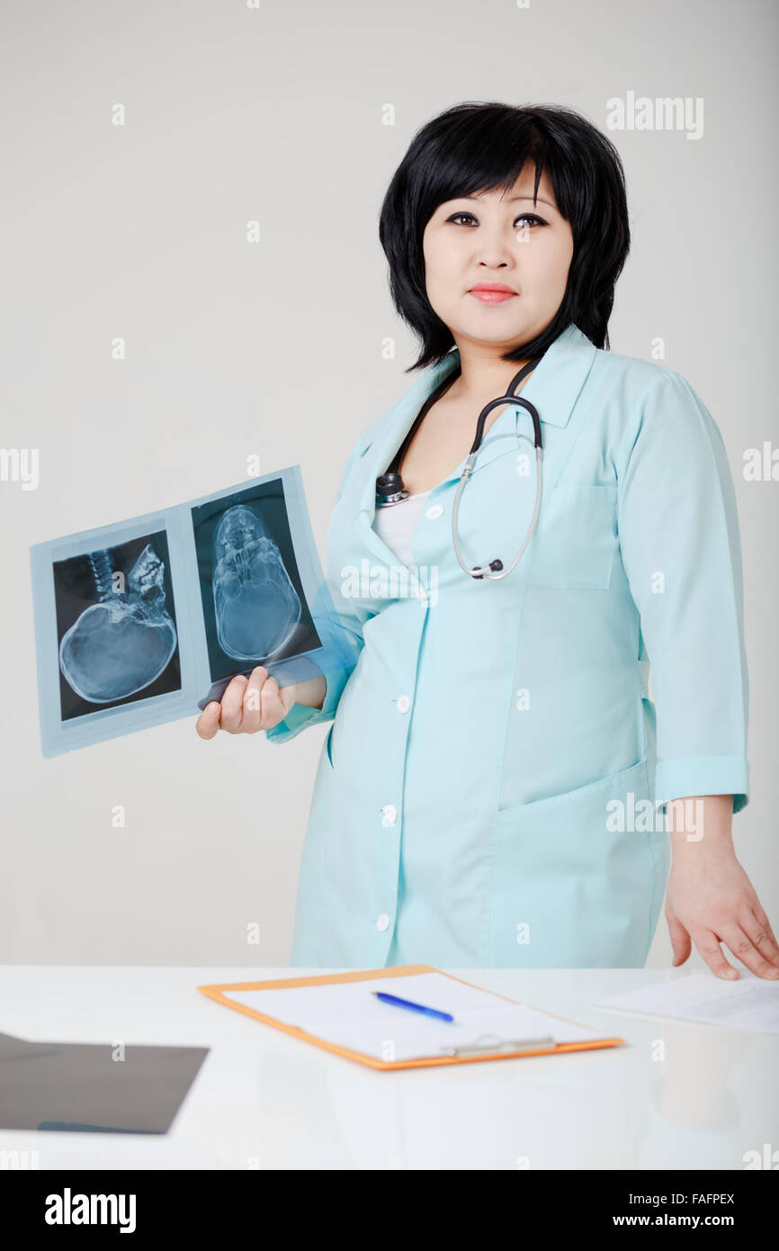 Junge asiatische Ärztin suchen direkt mit der Röntgen-Bildern Stockfoto