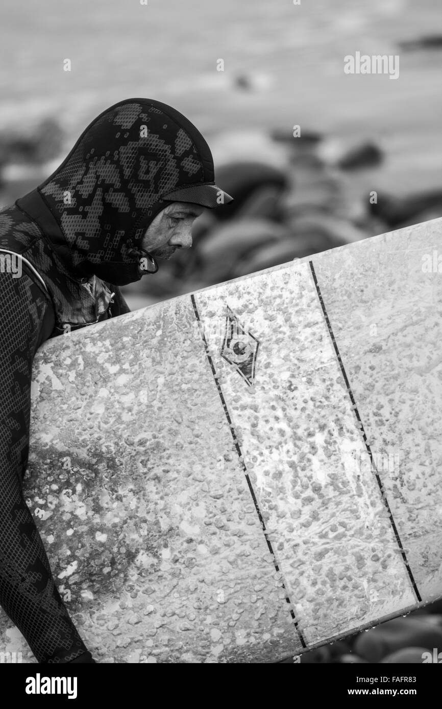 Eine Surfer vor der Westküste von Wales nutzt eine Pause im Sturm Frank Stockfoto