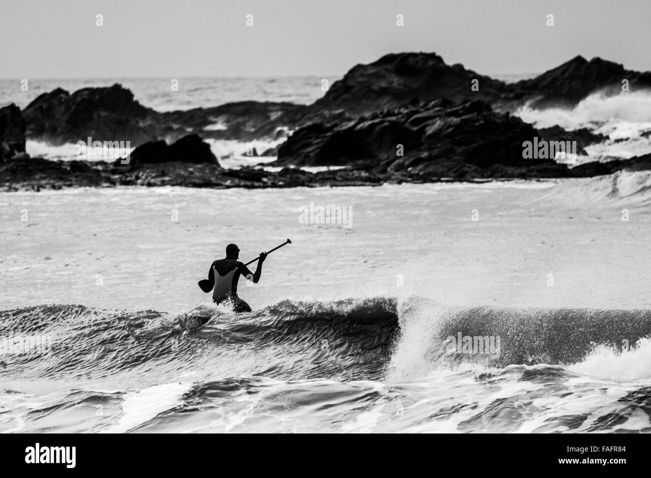 Eine Surfer vor der Westküste von Wales nutzt eine Pause im Sturm Frank Stockfoto