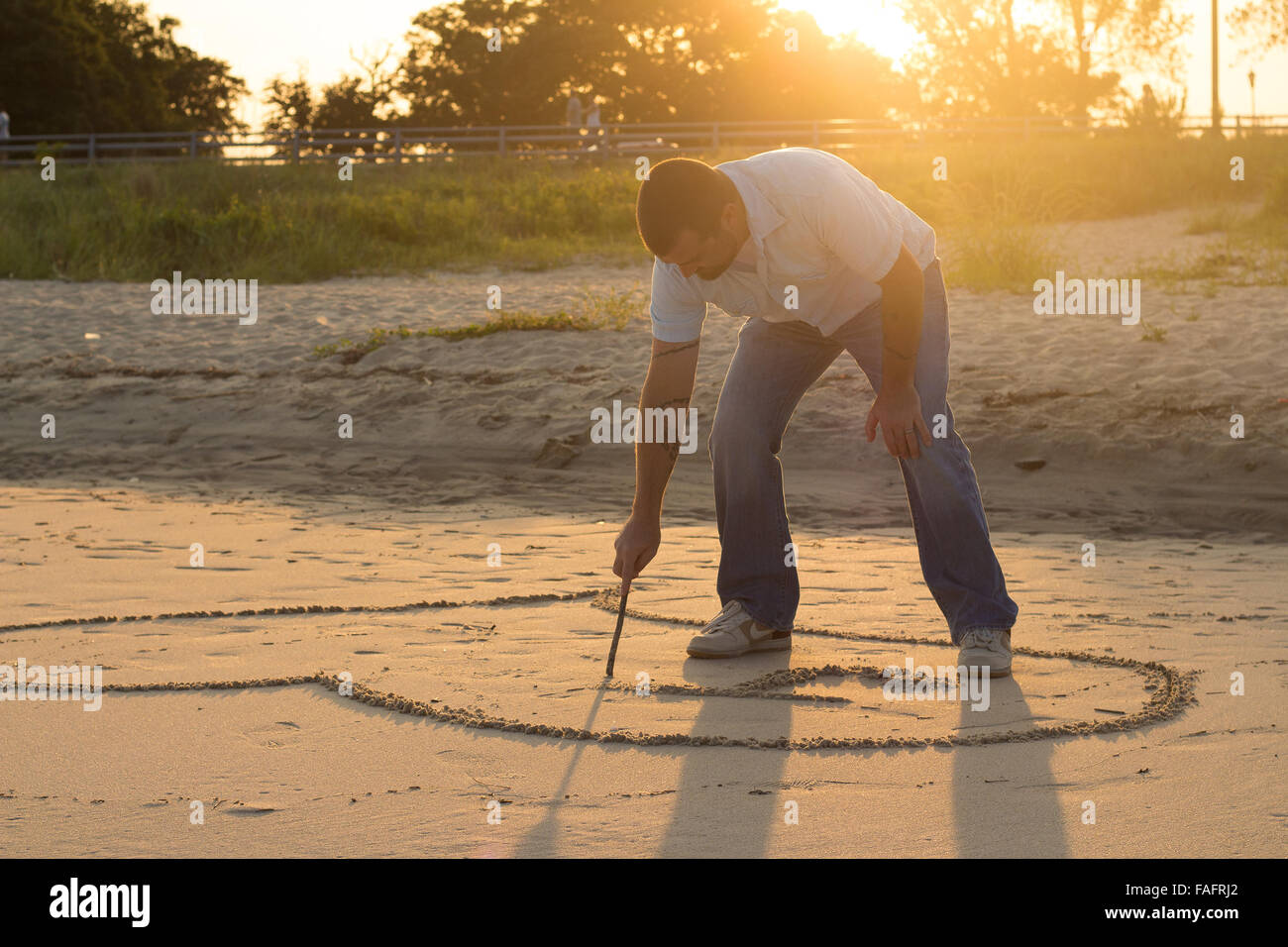 Menschen zeichnen ein Herz in den Sand. Stockfoto