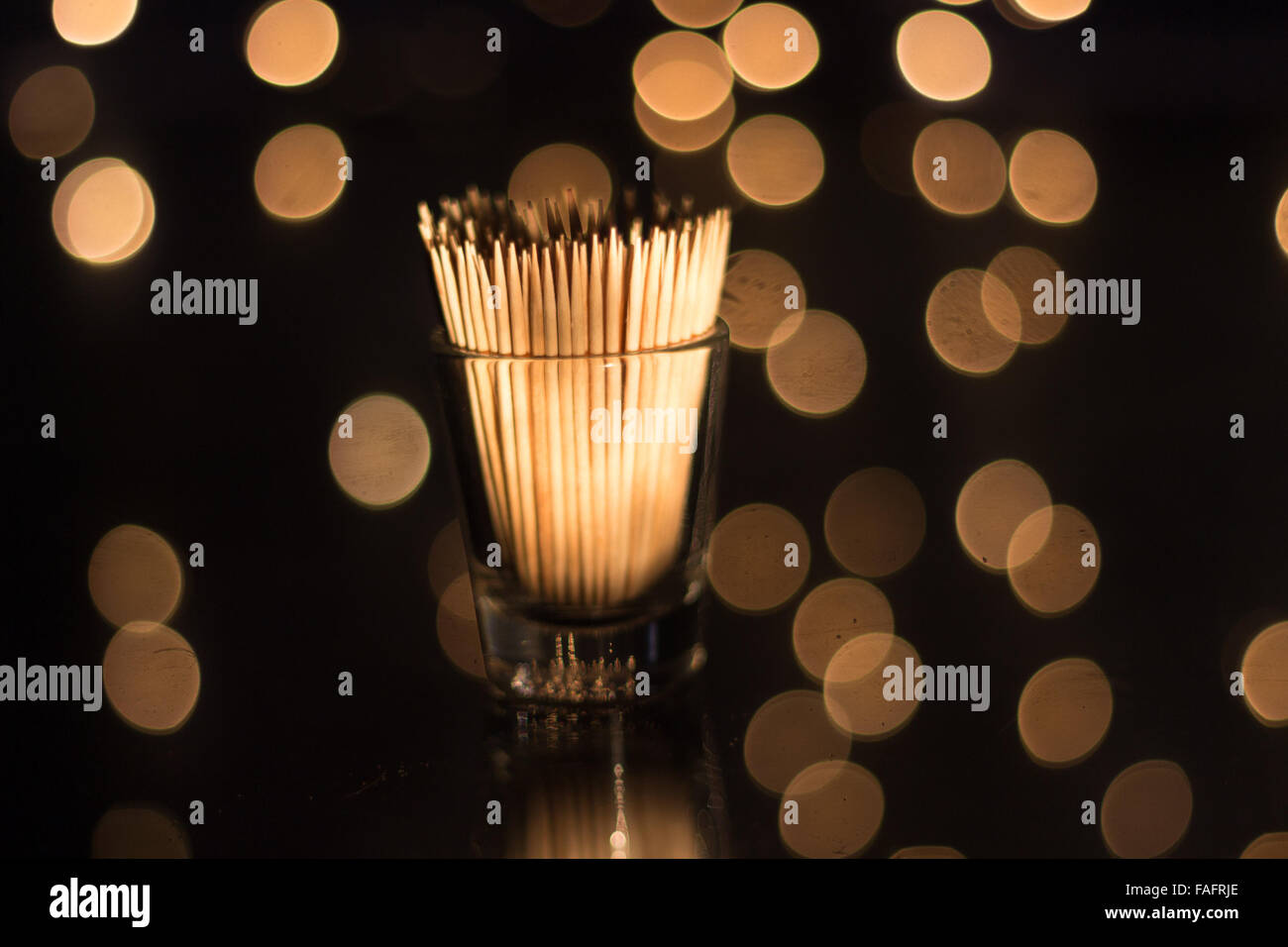 Zahnstocher in einem Schnapsglas mit einem warmen Bokeh. Stockfoto