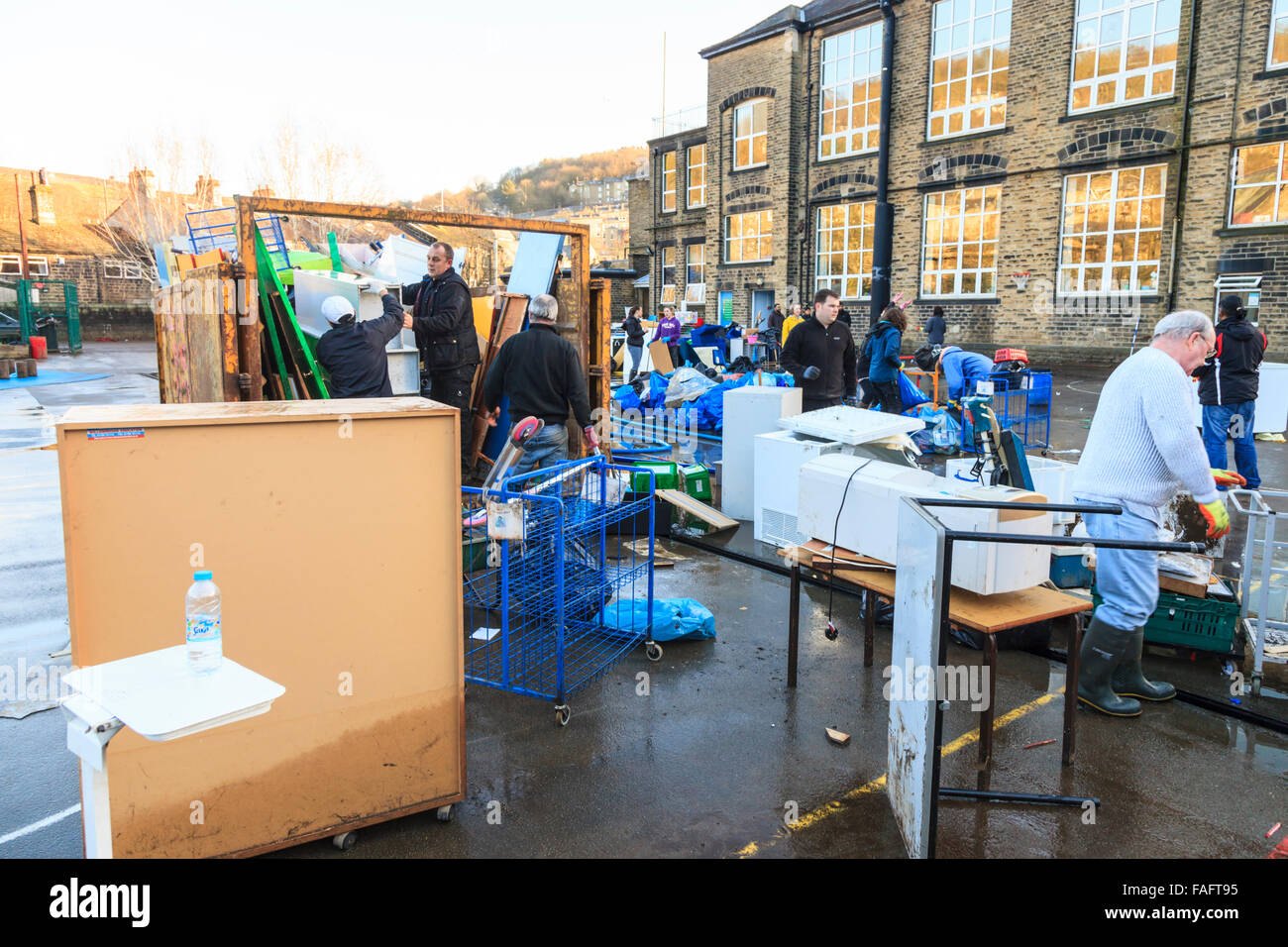 Hebden Bridge, UK. 29. Dezember 2015. Schulmöbel, Bücher und Ausrüstung, zerstört in den Fluten Hebden Bridge Boxing Day werden auf dem Schulhof von Riverside Junior gestapelt, während Freiwillige in Mulden und Transporter laden. Bildnachweis: Graham Hardy/Alamy Live-Nachrichten Stockfoto