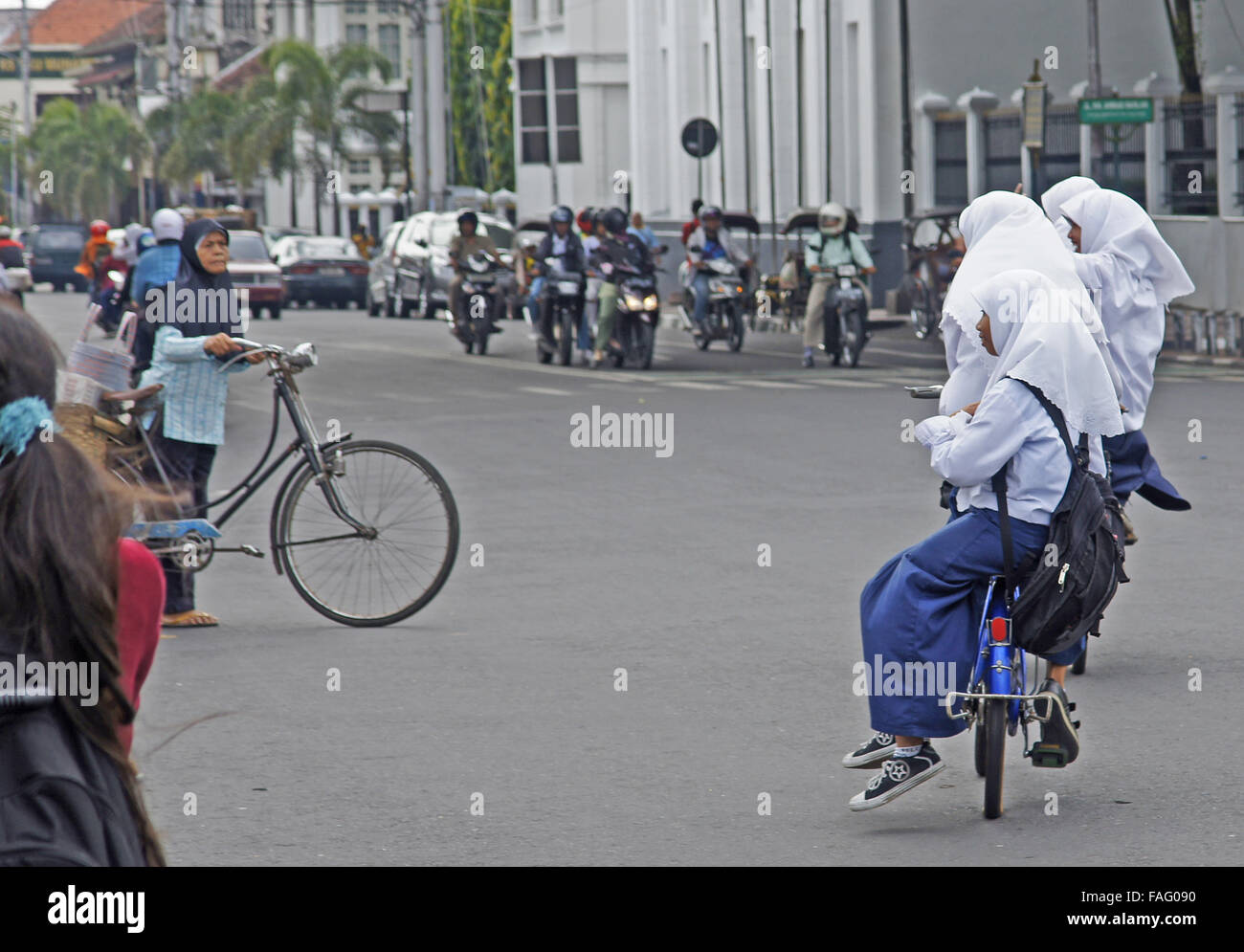 Schulmädchen Sozius fahren Fahrrad auf dem Heimweg von der Schule in Yogyakarta, Indonesien Stockfoto