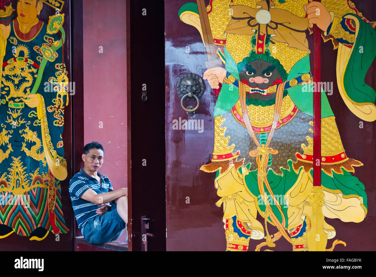 Mann, sitzend mit bemalten Tür Chenghuang Tempel (City God Temple), Shanghai, China Stockfoto