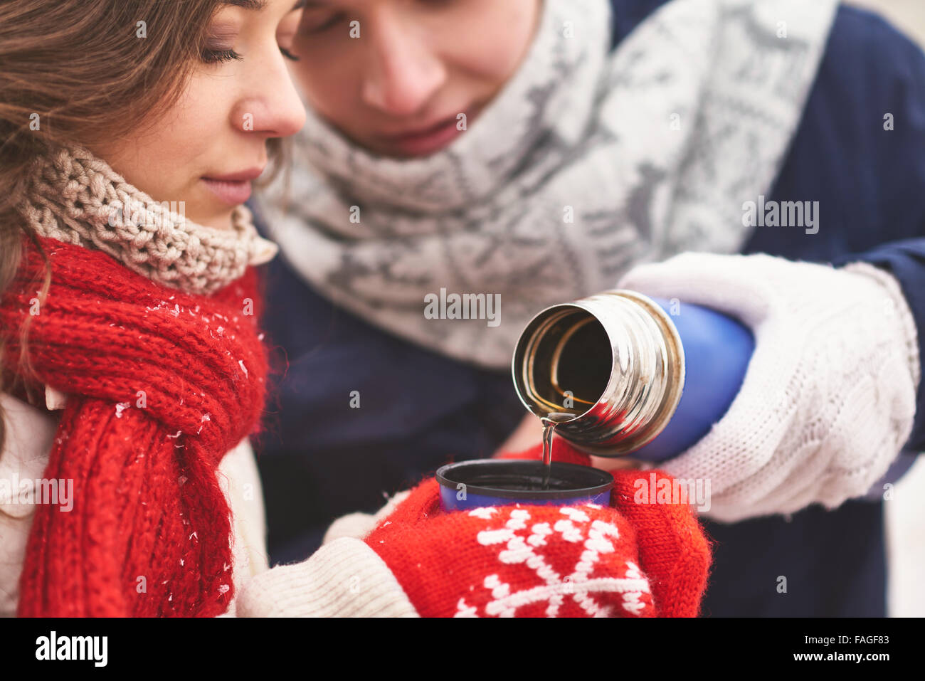 Junge Kerl strömenden heißen Tee für seine Freundin Stockfoto