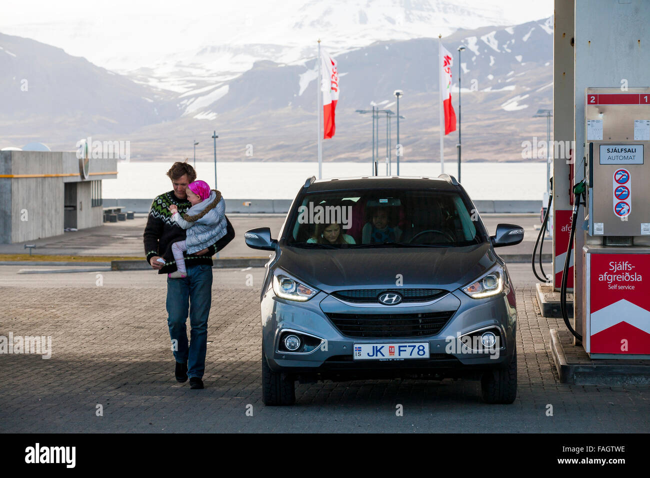 Ein Mann trägt sein Kind in einer Tankstelle nach dem Tanken von Kraftstoff auf die Straße von Rekyavik nach der Westfjorde Islands Stockfoto