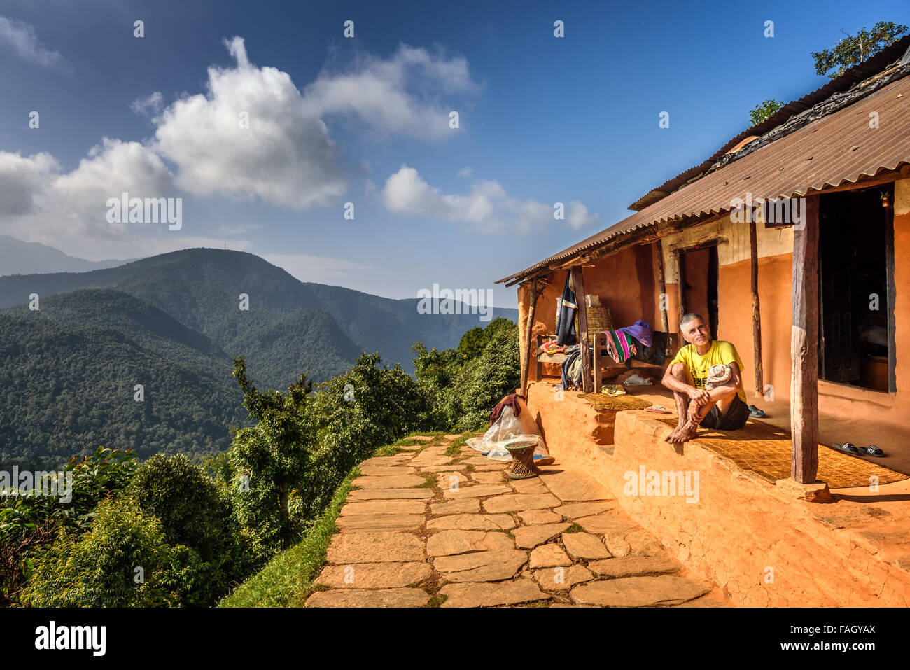 Nepalesische Mann sitzt vor seinem Haus in den Himalaya-Bergen Stockfoto