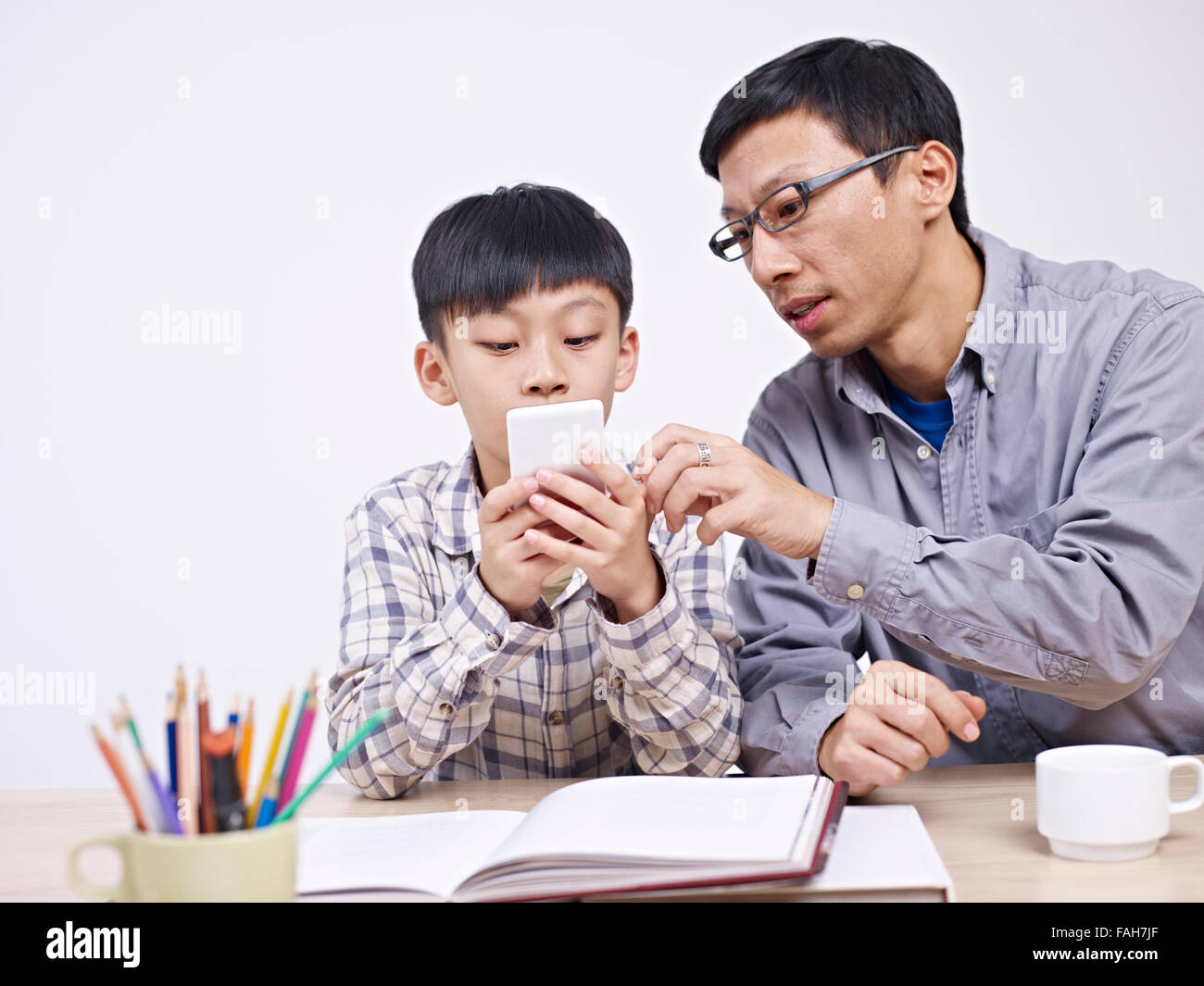 Vater und Sohn zusammen mit dem Handy zu spielen. Stockfoto