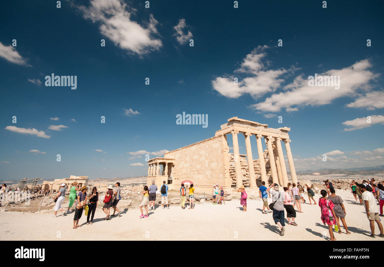 Touristen auf der Suche im alten griechischen Tempel des Erechtheions oder Erechtheion auf der Seite der Akropolis in Athen Stockfoto