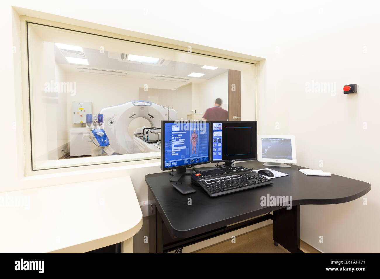 Ein Scan Raum mit Computern und Monitoren neben den CT-Scan-Raum in einem neuen modernen Krebs Behandlung Krankenhaus. Stockfoto