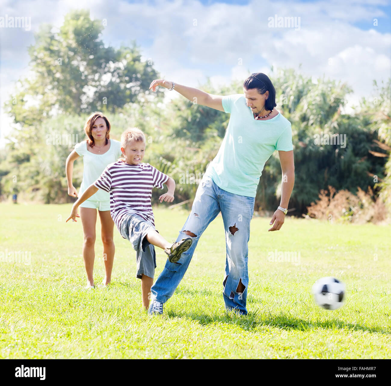 Paar mittleren Alters mit jungen spielen mit Fußball Sommer Pari Stockfoto