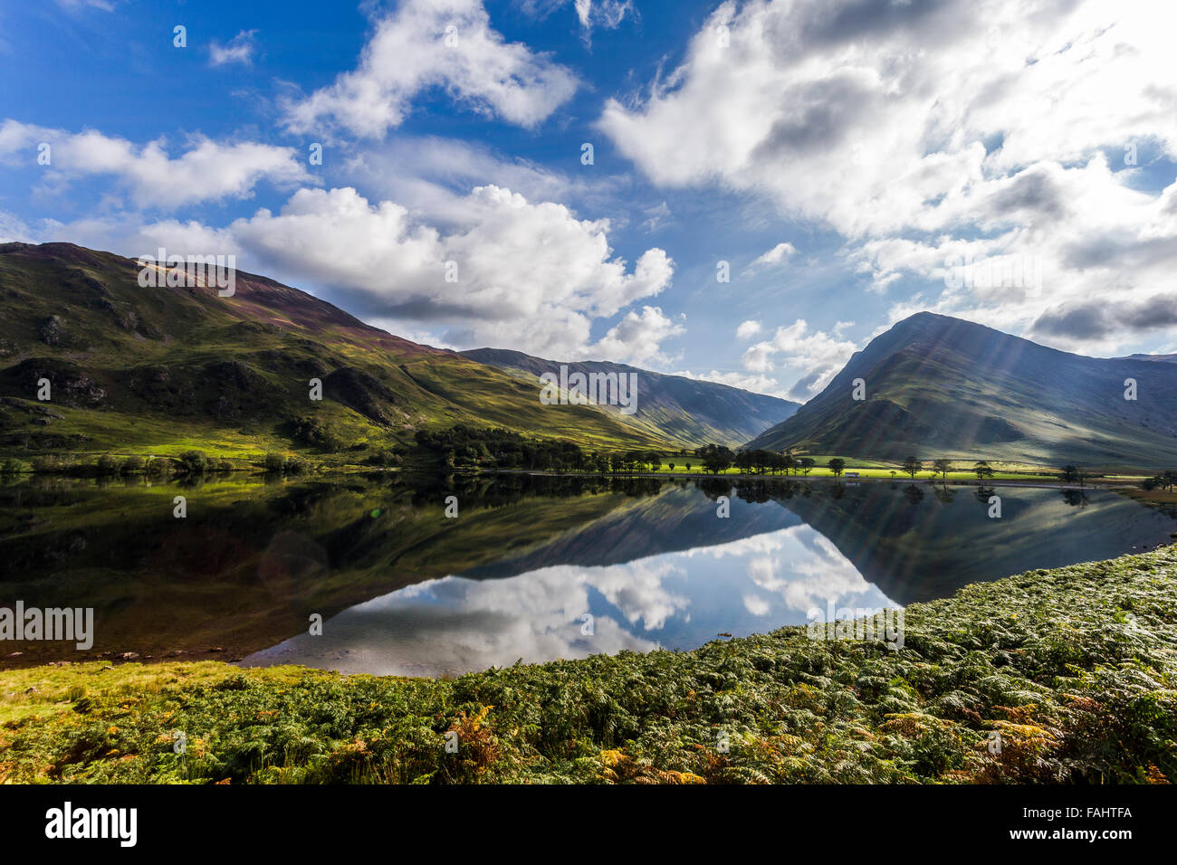 Lake Buttermere reflektieren die umliegenden Hügel an einem hellen sonnigen frühen Herbsttag Stockfoto