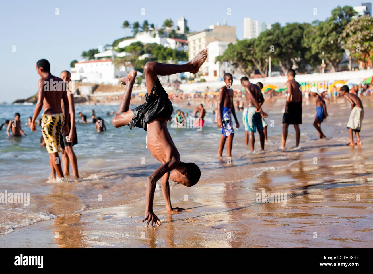 Einheimische Kinder Flucht vor Karneval Hitze am Porto da Barra Strand im Zentrum von Salvador da Bahia, Brasilien. Stockfoto