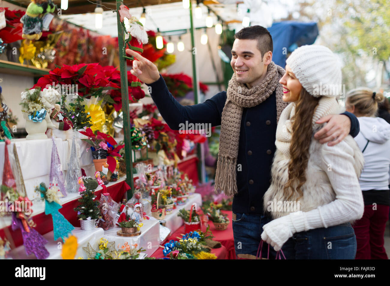 Spanische Eltern am Schalter des x-mas Markt lächelnd. Geringe Schärfentiefe Fokus nur auf den Menschen Stockfoto