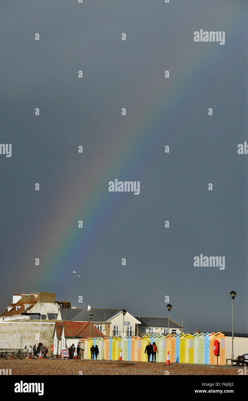 Seaford Sussex 31. Dezember 2015 - ein Regenbogen leuchtet dunkle Gewitterwolken über Strandhütten entlang Seaford Strandpromenade heute in East Sussex als das Ende des Sturms Frank Großbritannien Kredit geht: Simon Dack/Alamy Live News Stockfoto