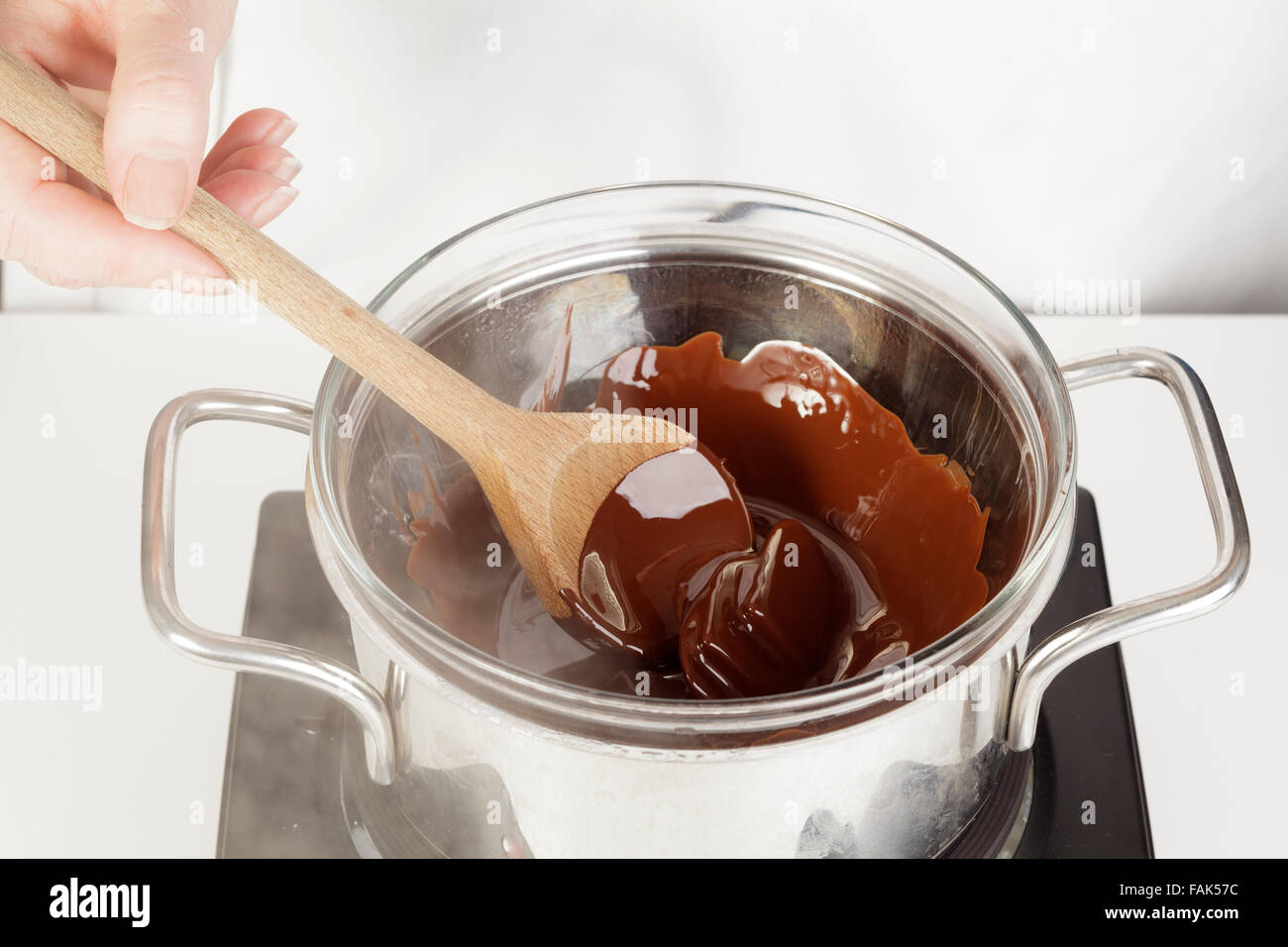 Schmelzen von Schokolade im Topf in Wasser als Bain Marie Stockfoto