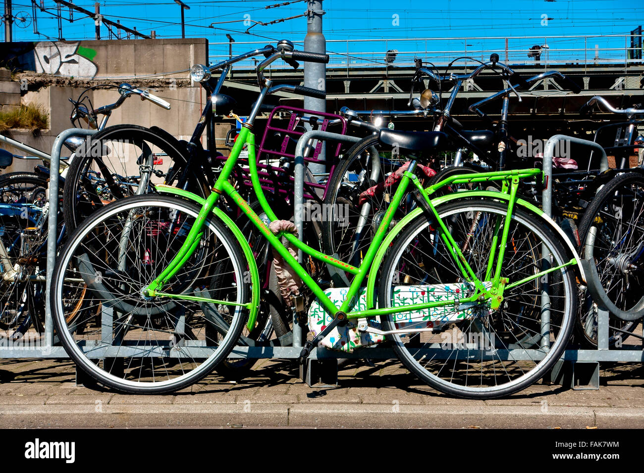 Grünes Fahrrad in der Nähe der Bahn geparkt. Amsterdam, Holland, Niederlande, Europa, EU. Klimawandel, globale Erwärmung. Umweltfreundliche alternative Verkehrsmittel. Stockfoto