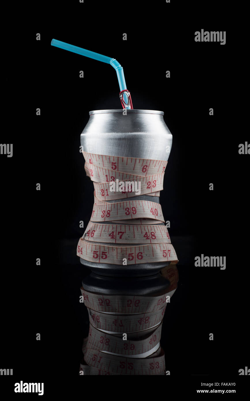 Dose Cola-Getränk mit Maßband zeigt schlanke Taille. Stockfoto
