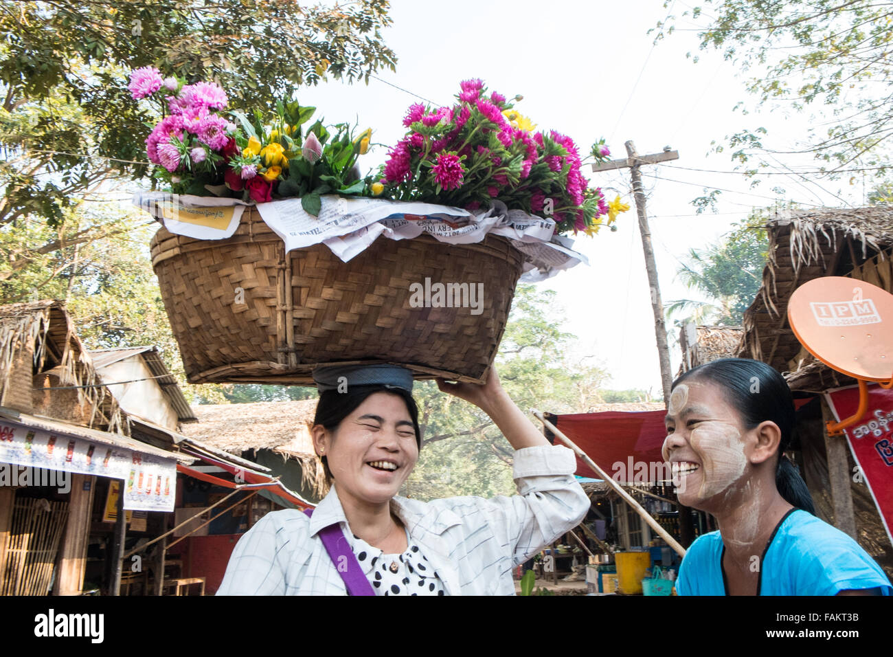 Golden, rock, Myanmar, Burma, Gold, Kyaitiyo, buddhistische, Blumenkorb Verkäuferin Headloading Blumen am Kyaitiyo Stadt Markttag. Stockfoto