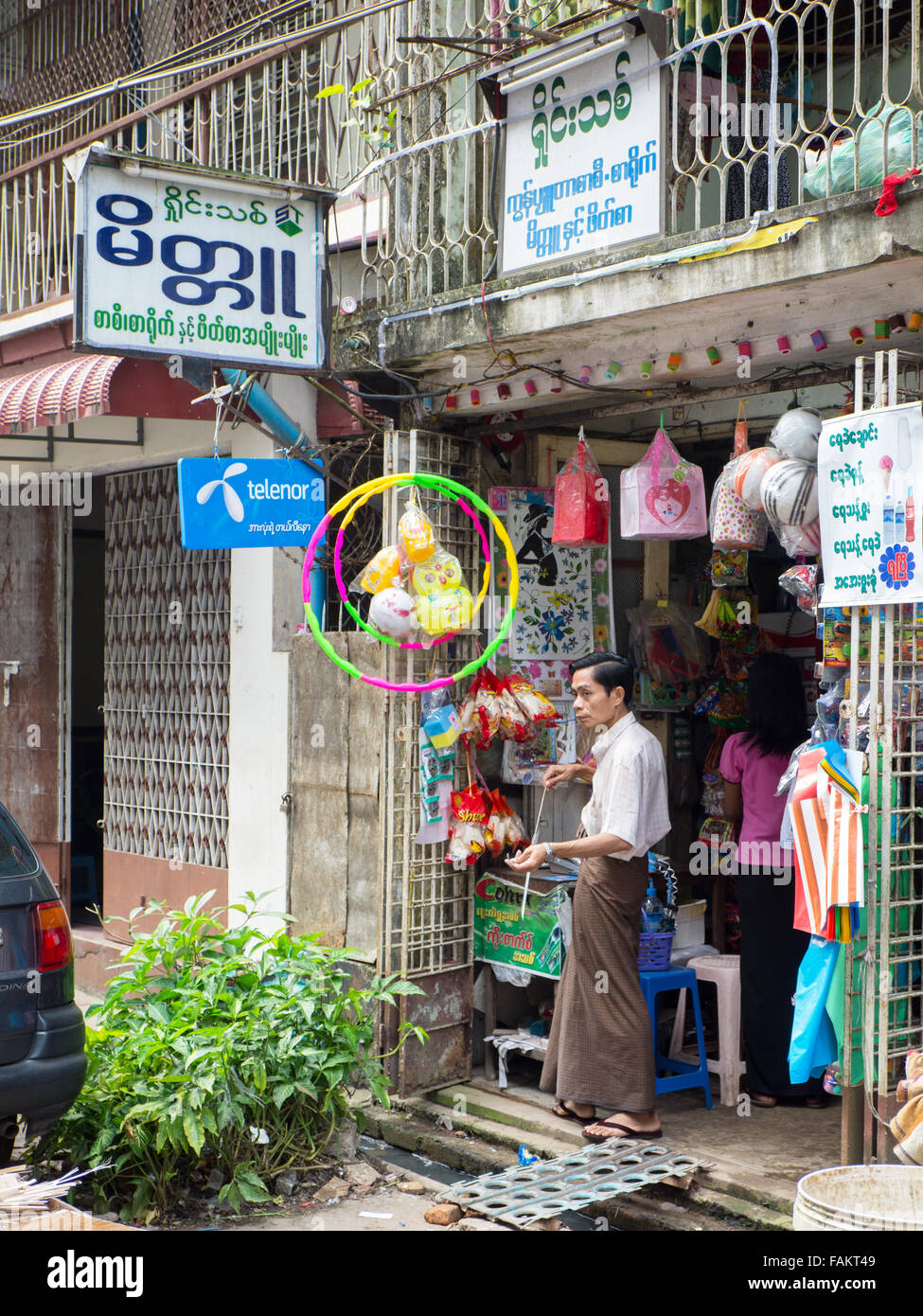 Shop-Betreiber vor seinem Geschäft in der Dhanmayone Straße in Yangon. Stockfoto