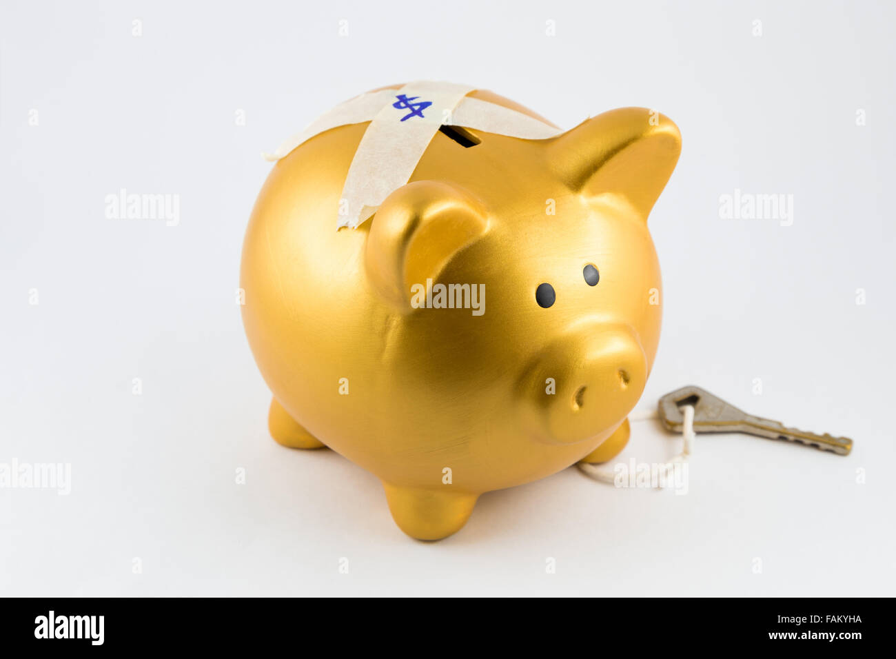 Piggy Bank in gold Farbe ist auf dem Rücken gesperrt. Die Taste gedrückt halten auf dem Bein. Sie sind auf einem isolierten Hintergrund. Stockfoto