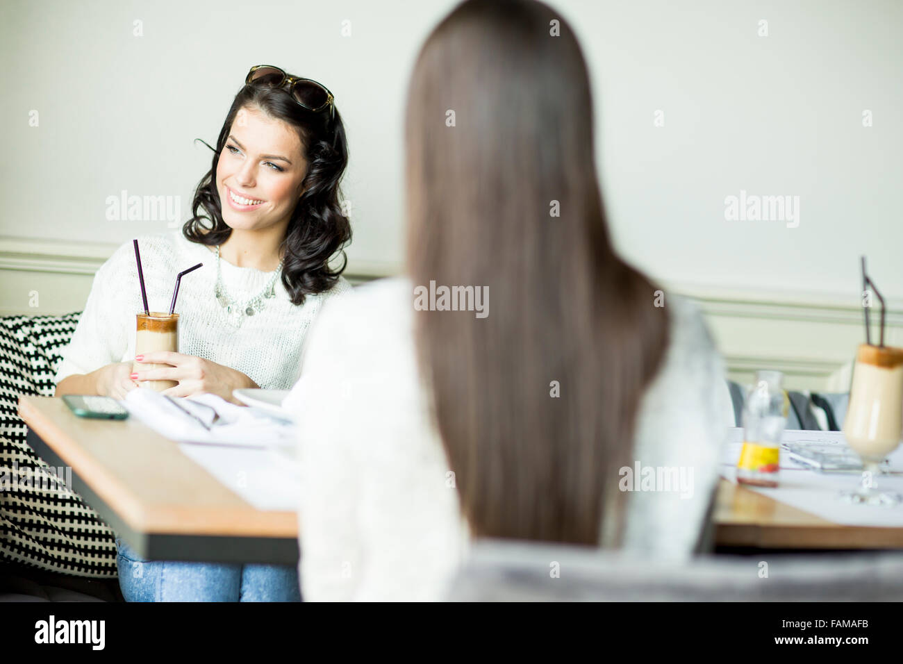 Zwei Junge Frauen Sitzen Im Cafe Fotos Und Bildmaterial In Hoher