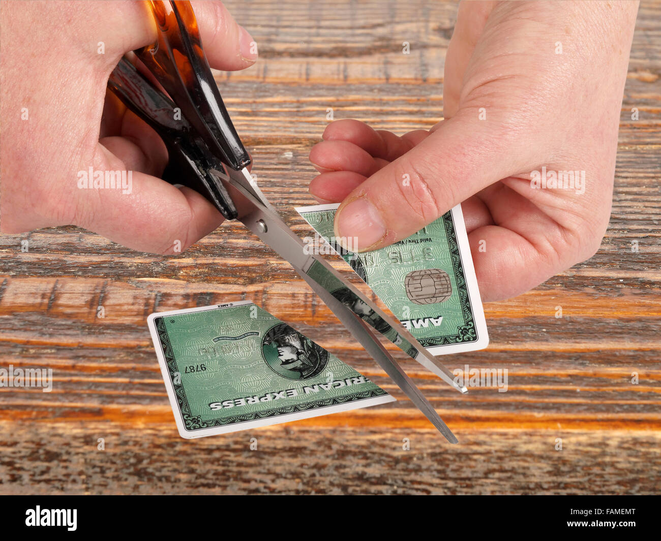 Studioaufnahme von weiblichen Händen schneiden American Express Kreditkarte. Stockfoto