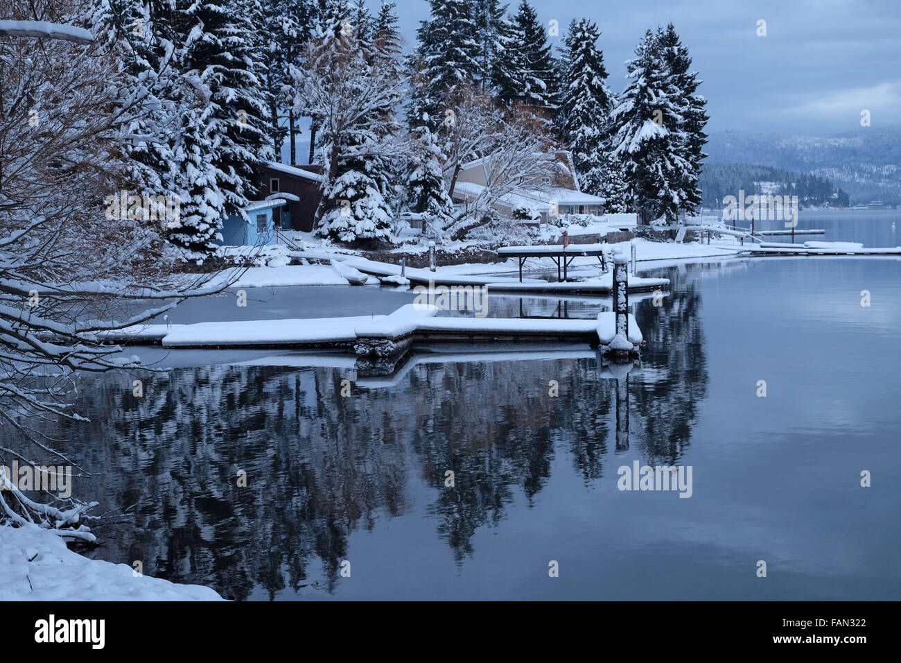 Docks auf Hayden Lake, Idaho nach Neuschnee fallen.  Bäume auf dem See widerspiegeln. Stockfoto