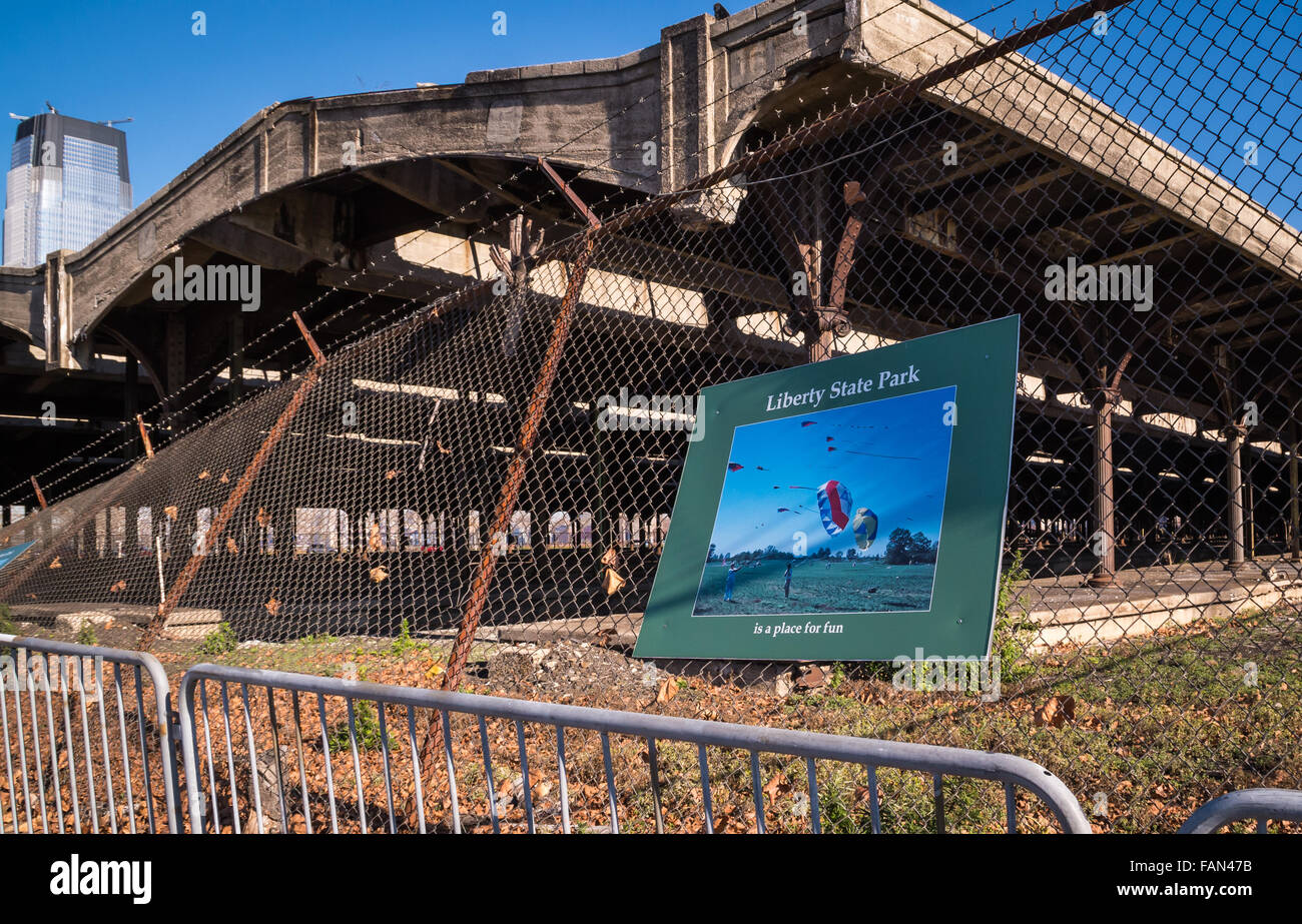 Vom Zeichen auf dem eingestürzten Zaun rund um das Central Railroad of New Jersey Terminal im Liberty State Park in Jersey City. Stockfoto
