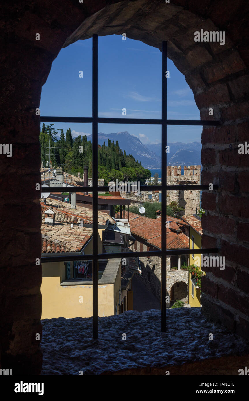 Blick auf den Gardasee (Italien) und Sirmione Altstadt durch alte Fenster von Scaliger Burg (Sirmione, Italien). Stockfoto