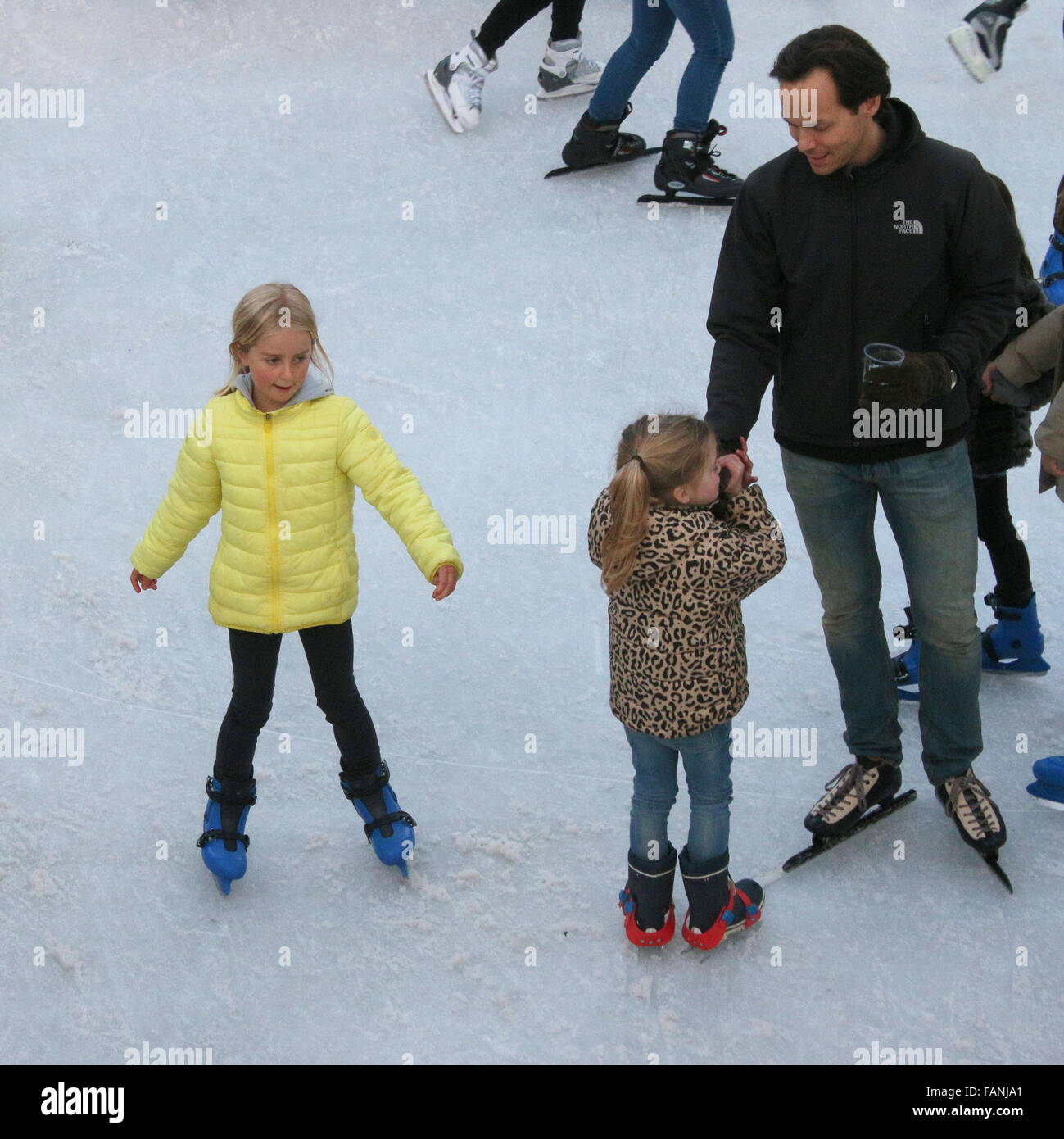 Mann und zwei Mädchen Skaten auf der temporäre Eisbahn am Museumplein (Museumsplatz), Amsterdam, Niederlande Stockfoto