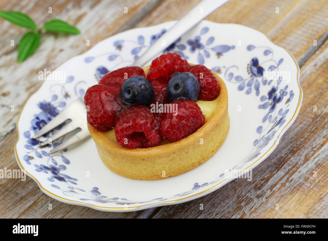 Sahne-Torte mit Himbeeren und Heidelbeeren auf Vintage Teller, Nahaufnahme Stockfoto