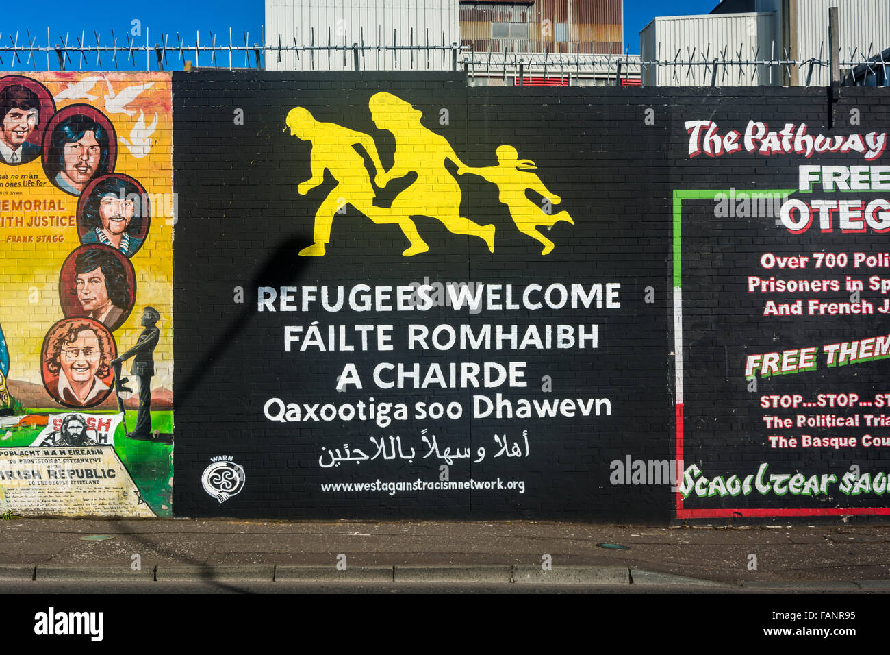 Flüchtlinge willkommen Wandbild am internationalen Wand auf Belfast Falls Road. Mit Gälisch Text. Stockfoto