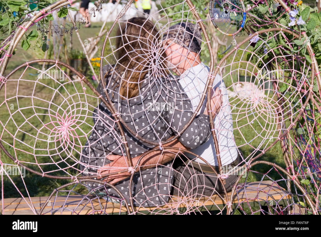 CHEPSTOW, WALES - Juli 2014: Paar genießen einen privaten Moment in der Liebe-Sitz am 31. Juli auf dem Grün Gathering festival Stockfoto